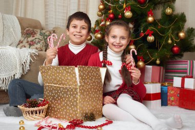 Çocuk Noel ağacı, ev dekorasyon, mutlu duygu, kış tatil kavramı yakınındaki hediye kutuları açmak