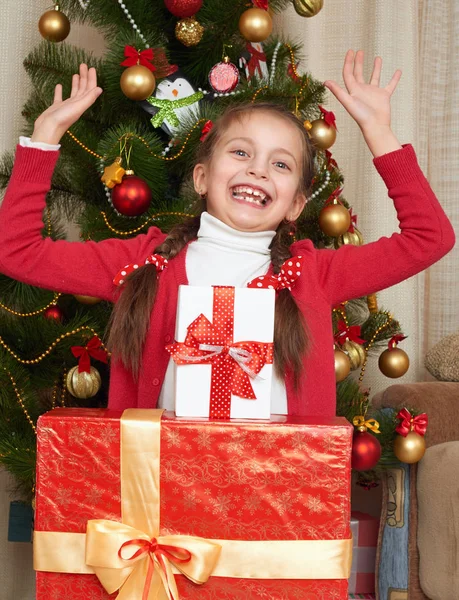 Ragazza vicino all'albero di Natale e scatole regalo, festa felice e festa invernale, vestita di rosso — Foto Stock