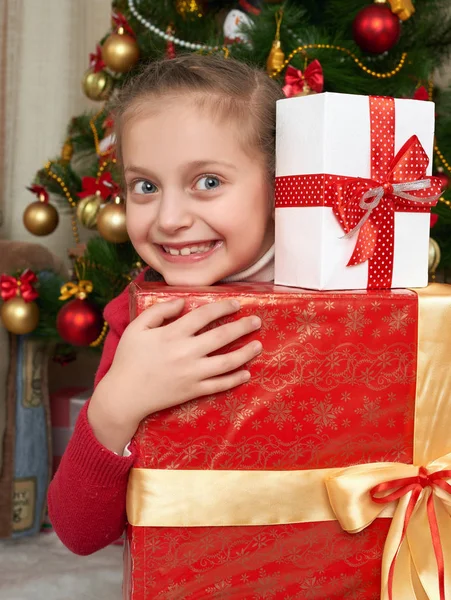 Menina com caixas de presente perto da árvore de Natal, férias felizes e celebração de inverno — Fotografia de Stock