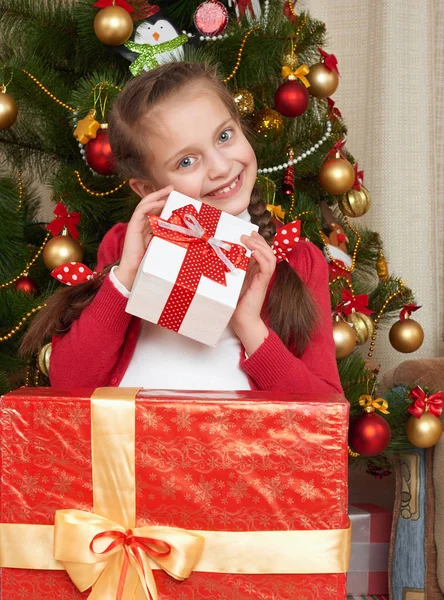 Ragazza vicino all'albero di Natale e scatole regalo, festa felice e festa invernale, vestita di rosso — Foto Stock