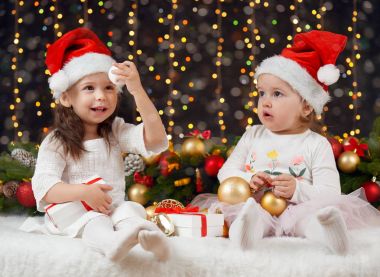 Noel dekorasyon hediye, aydınlatma ve Böke ışıklar, koyu arka plan ile'de iki kız kış tatil kavramı