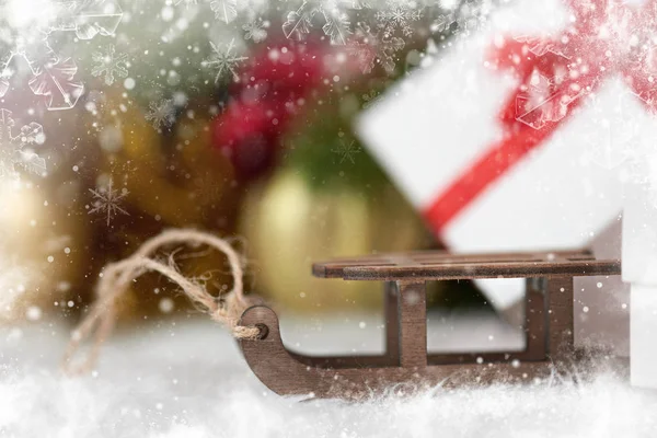 Spielzeugschlitten und Weihnachtsschmuck als Hintergrund, verziert mit Schnee — Stockfoto