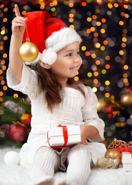 Девушка в рождественском украшении с подарком, темный фон с освещением и бокс-огни, зимний праздник концепции — стоковое фото