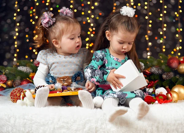 Две девушки распаковать подарки в рождественском оформлении, темный фон с освещением и boke огни, зимний праздник концепции — стоковое фото