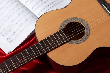 akustik gitar ve müzik notlar kırmızı kumaş, nesnelerin görünümünü kapat