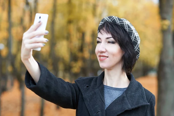 Chica tomando selfie en otoño parque de la ciudad, hojas amarillas y árboles, temporada de otoño —  Fotos de Stock