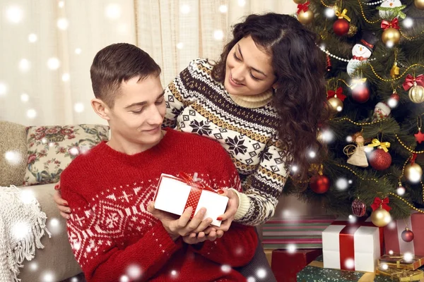 幸福的夫妇在圣诞节装饰在家中赠送礼物。新年前夕, ornated 枞树。寒假与爱情观. — 图库照片