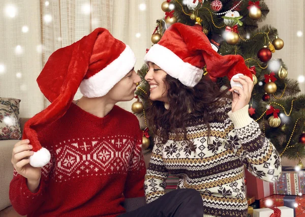 Felice bacio di coppia nella decorazione di Natale a casa. Vigilia di anno nuovo, abete ornato. Vacanza invernale e concetto di amore . — Foto Stock