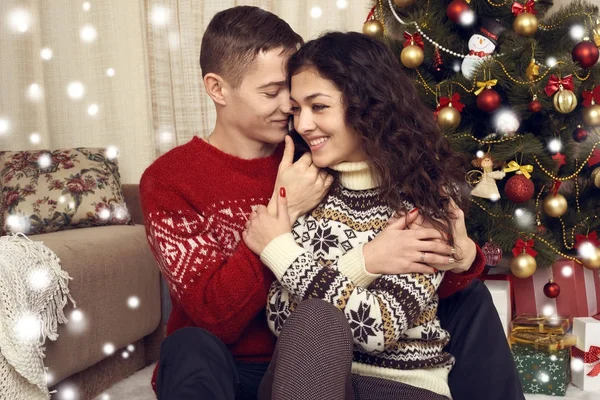 Ευτυχισμένο ζευγάρι στη χριστουγεννιάτικη διακόσμηση στο σπίτι. Πρωτοχρονιάς, διακοσμημένους έλατο. Χειμερινές διακοπές και την αγάπη έννοια. — Φωτογραφία Αρχείου