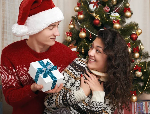 Giovane coppia insieme con albero di Natale e regali in casa interiore - amore e concetto di vacanza, vigilia di Natale — Foto Stock