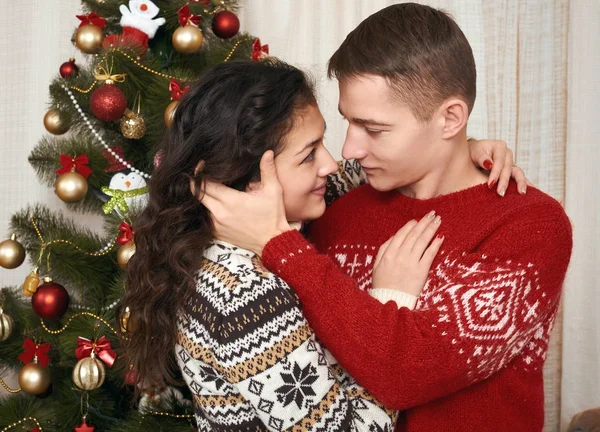 Νεαρό ζευγάρι μαζί με το χριστουγεννιάτικο δέντρο στο σπίτι εσωτερικό - αγάπη και διακοπές έννοια, παραμονές Χριστούγεννα — Φωτογραφία Αρχείου