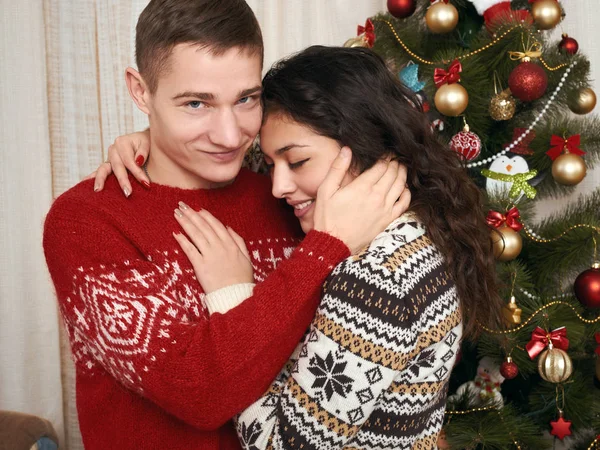 Jovem casal em conjunto com a árvore de Natal no interior da casa - conceito de amor e férias, véspera de Natal — Fotografia de Stock