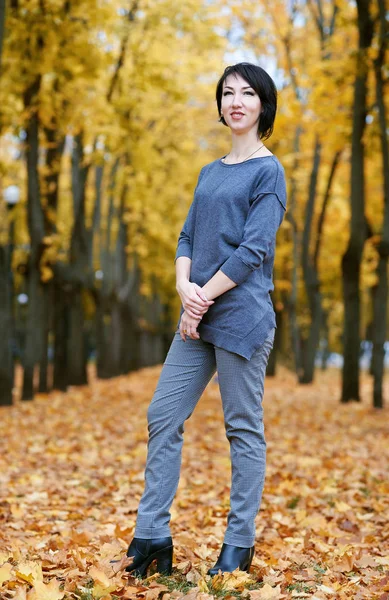 Mädchenstand im Herbstpark mit gelben Bäumen, Herbstsaison — Stockfoto