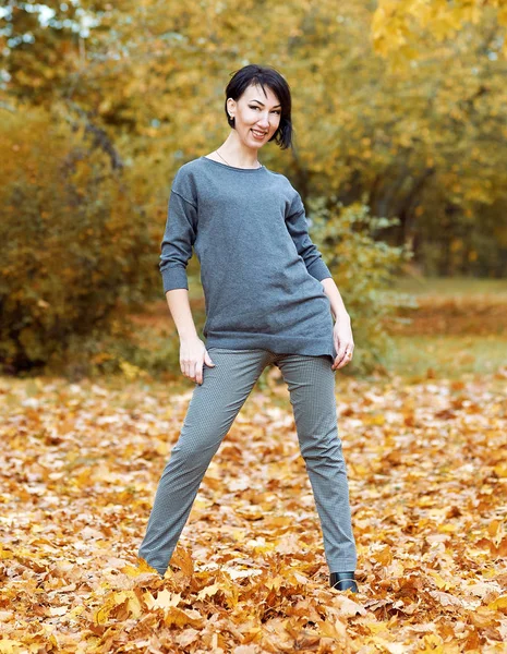 Meisje stand op gele bladeren in de herfst park met bomen, herfst — Stockfoto