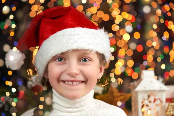暗い照らされた背景、新年あけましておめでとうございます、冬の祭典概念クリスマス プレゼントとサンタ帽子に身を包んだ女の子子供 — ストック写真