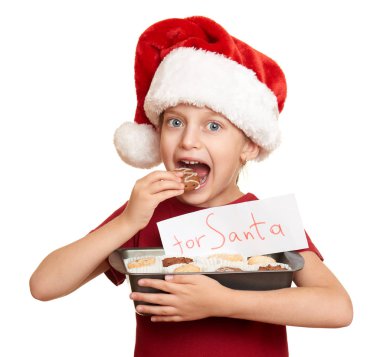 Çocuk beyaz arka plan üzerinde izole çerezler ile santa şapka giymiş. Yeni yıl arifesi ve kış tatil kavramı.