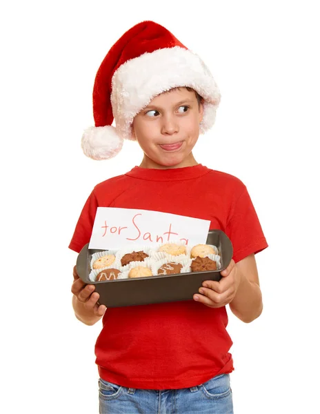 Παιδί ντυμένος με καπέλο santa με τα cookies που απομονώνονται σε λευκό φόντο. Νέο έτος eve και το χειμώνα διακοπές έννοια. — Φωτογραφία Αρχείου