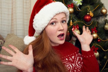 Kız evde Noel dekorasyon Noel Baba olarak giyinmiş. Yeni yıl arifesi ve kış tatil kavramı.