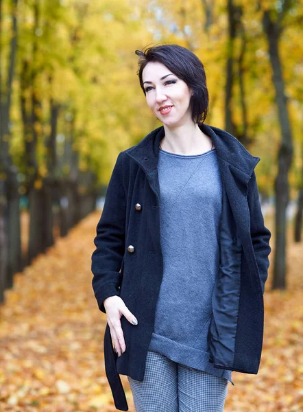 Young woman posing in autumn park with yellow trees, fall season — Stock Photo, Image