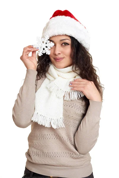 美丽的女孩肖像穿着圣诞老人的帽子显示大雪花玩具。白色隔离背景。新年前夕和寒假概念. — 图库照片