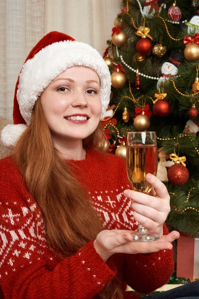 Dziewczyna z szampanem w stroju Świętego Mikołaja w świąteczne dekoracje w domu. Nowy rok eve i zimowe wakacje koncepcja. — Zdjęcie stockowe