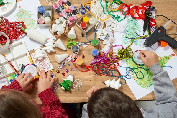 I bambini fanno artigianato e giocattoli, albero di Natale e altro. Dipingere acquerelli. Vista dall'alto. Lavoro d'arte con accessori creativi. Strumenti di arte laica piatto . — Foto Stock