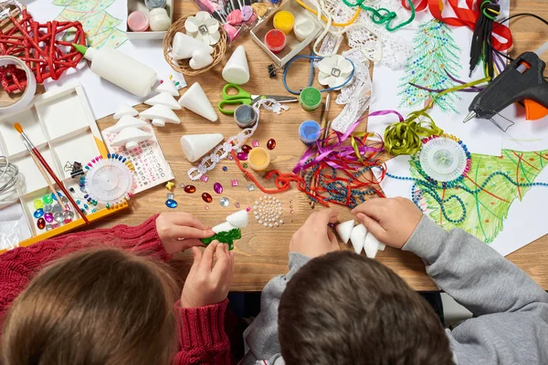 Los niños hacen manualidades y juguetes, árbol de navidad y otros. Pintura acuarelas. Vista superior. Artwork lugar de trabajo con accesorios creativos. Herramientas planas de arte laico . — Foto de Stock