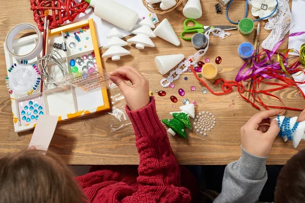 Los niños hacen manualidades y juguetes, árbol de navidad y otros. Pintura acuarelas. Vista superior. Artwork lugar de trabajo con accesorios creativos. Herramientas planas de arte laico . — Foto de Stock