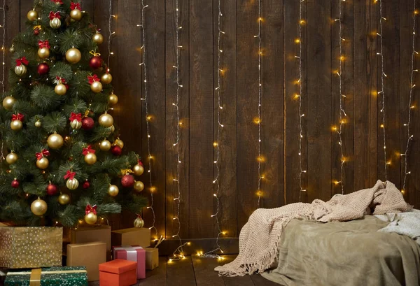 Intérieur de la maison avec mur en bois, lit, arbre de Noël et lumières , — Photo