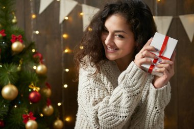 Hediye ile mutlu kadın kutu Noel dekorasyonu. Koyu ahşap iç ışıkları ile. Romantik akşam ve sevgi kavramı. Yeni yıl tatili.