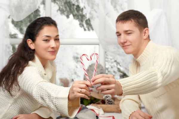 Jong koppel toont een hart van snoep, gelukkige mensen - romantische en hou van concept — Stockfoto