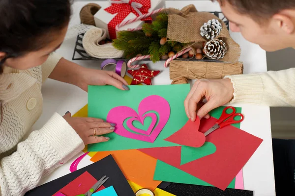Giovane coppia che fa decorazioni origami per San Valentino, vista dall'alto - concetto romantico e amore — Foto Stock