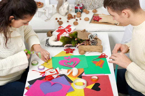 Giovane coppia che fa cuori di carta durante giorno di San Valentino, vista dall'alto - concetto romantico e d'amore — Foto Stock