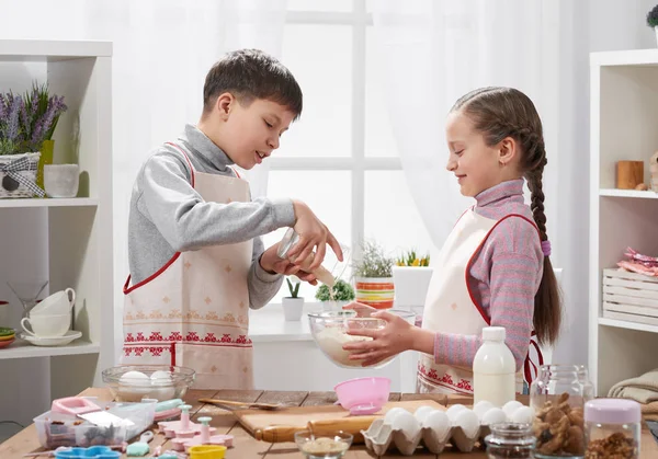 Девочка и мальчик готовят на домашней кухне, делают тесто для выпечки, концепцию здоровой пищи — стоковое фото