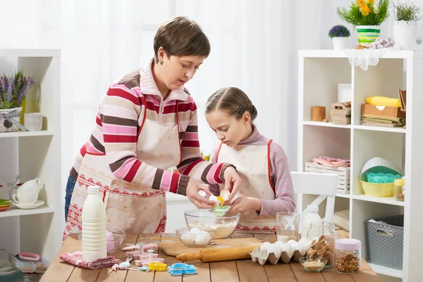 Anne ve kızı anne ve kızı break yumurta içine un, ev mutfak iç, sağlıklı yiyecek konsepti