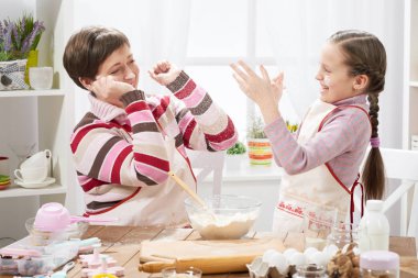 Anne ve kızı çörekler için hamur yapmak ve un ile ev mutfak iç, sağlıklı gıda kavramı oynamak