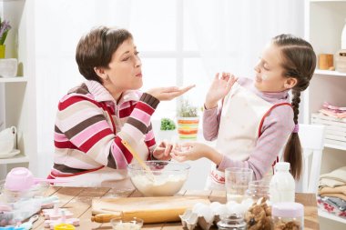 Anne ve kızı çörekler için hamur yapmak ve un ile ev mutfak iç, sağlıklı gıda kavramı oynamak