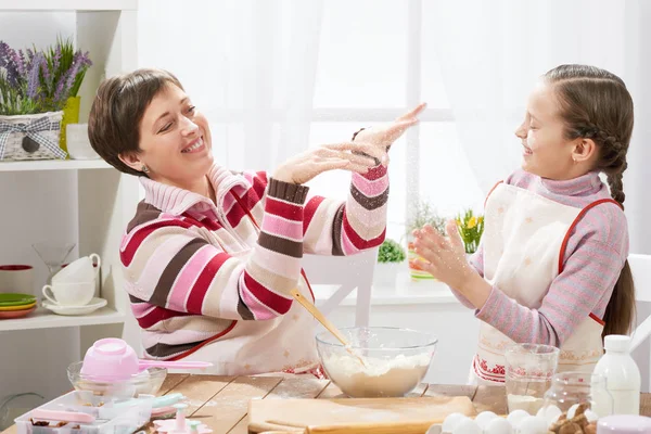Anne ve kızı çörekler için hamur yapmak ve un ile ev mutfak iç, sağlıklı gıda kavramı oynamak