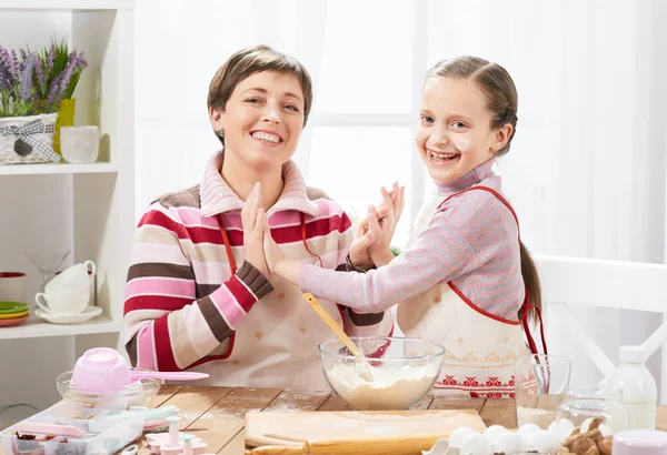 Anne ve kızı çörekler için hamur yapmak ve un ile ev mutfak iç, sağlıklı gıda kavramı oynamak