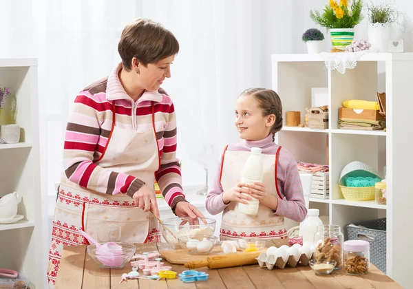 Mother and daughter cook at home. Making cookies, kitchen interior, healthy food concept
