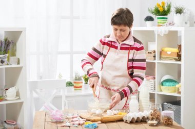 Evde kadın aşçı. çörekler için hamur yapmak