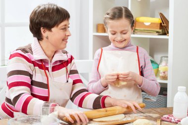 Anne ve kızı evde yemek, çörekler için hamur yapma