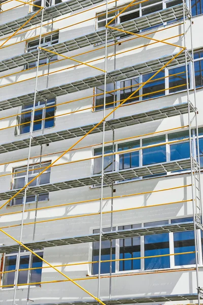 Gevel van het nieuwe huis met steigers, witte muur en raam — Stockfoto