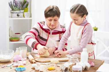 Anne ve kızı evde yemek, çörekler için hamur yapma