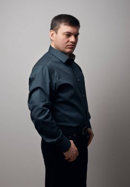 gri arka plan üzerinde gömlek ve siyah pantolon giymiş adam portresi