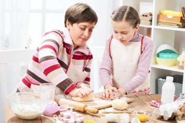Anne ve kızı evde yemek, çörekler için hamur yapma
