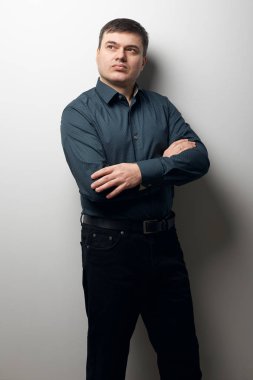 eller gri arka plan üzerinde koyu gömlek ve siyah pantolon giymiş, geçiş ile adam portresi