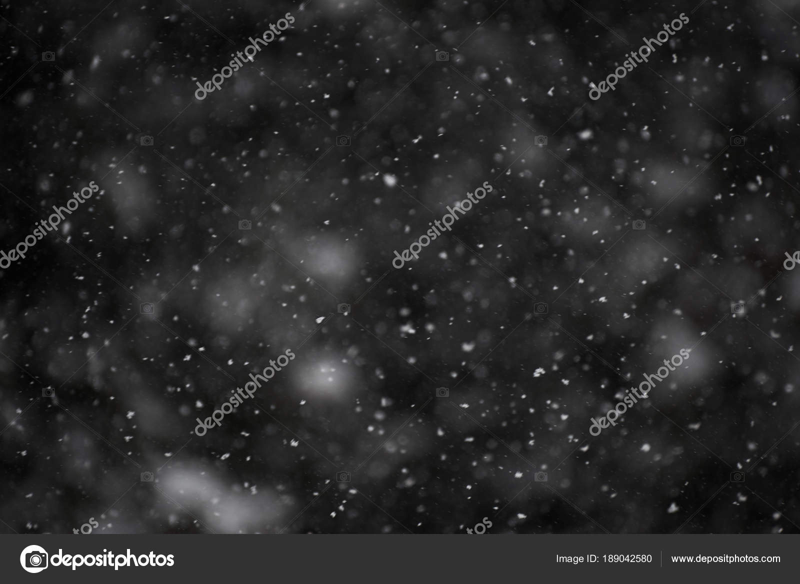 photo of natural snow falling on a dark background good to use as a