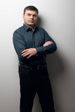 eller gri arka plan üzerinde koyu gömlek ve siyah pantolon giymiş, geçiş ile adam portresi