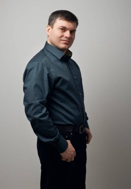 gri arka plan üzerinde gömlek ve siyah pantolon giymiş adam portresi
